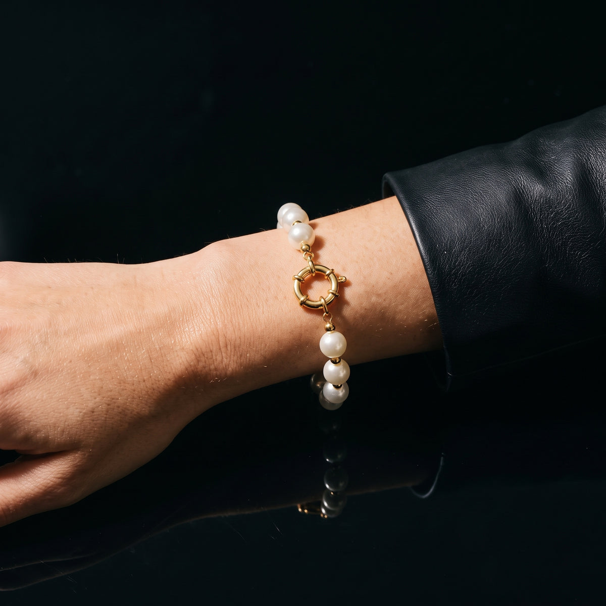 Bracelet de perles et fermoir doré porté au poignet